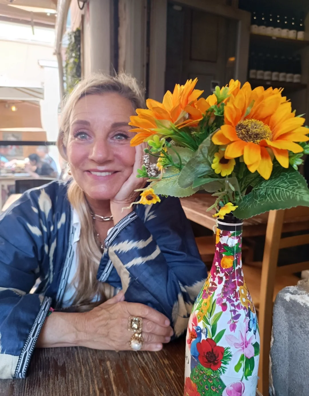 花が飾られたテーブルに座っている人