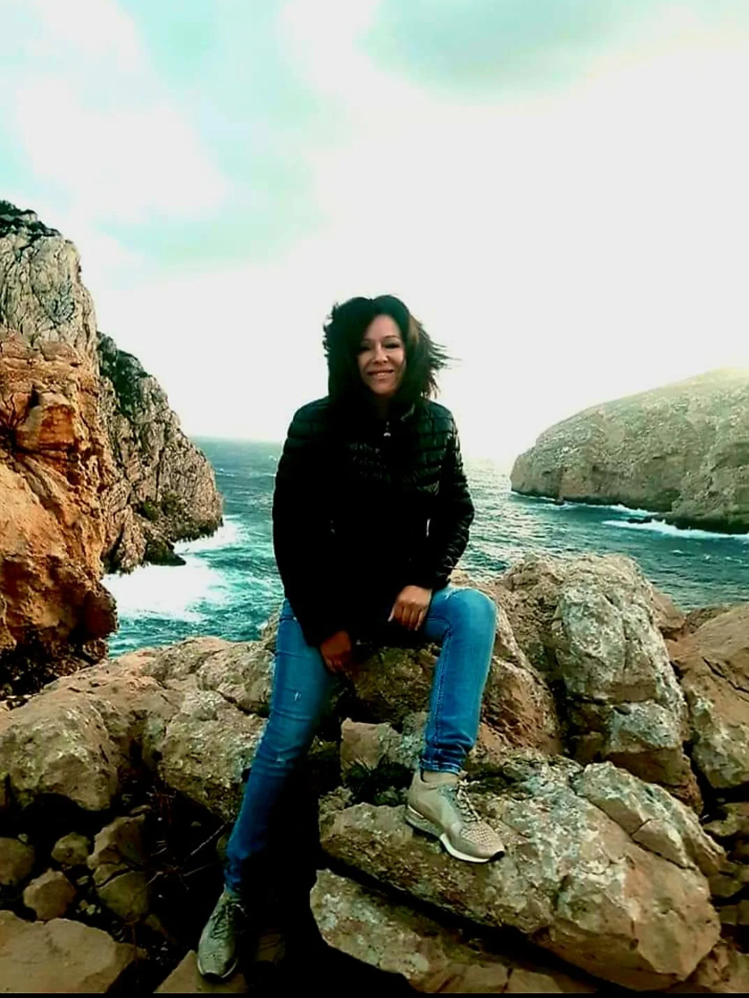 水辺の岩に座っている人