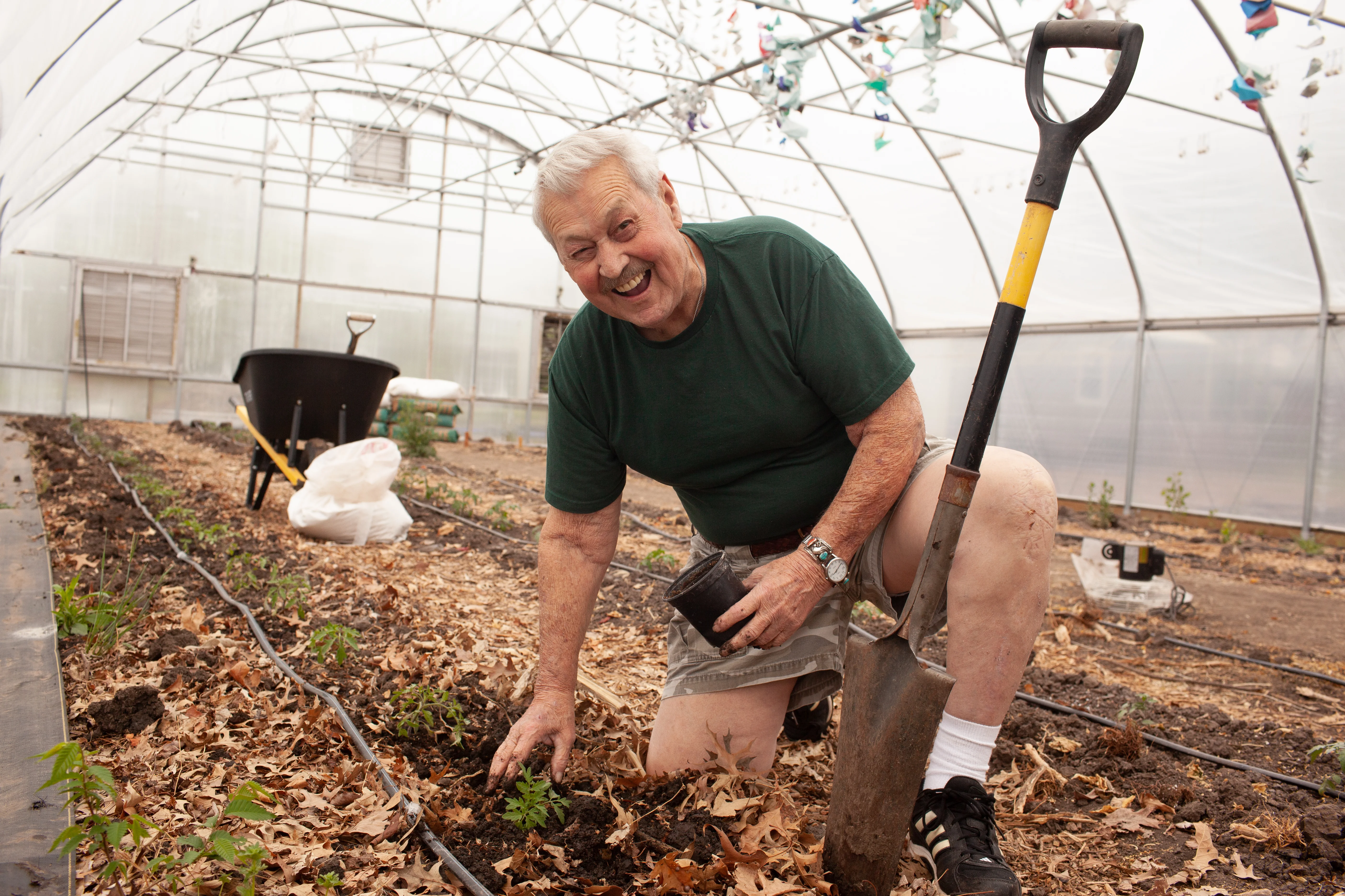a man planting plants and smiling