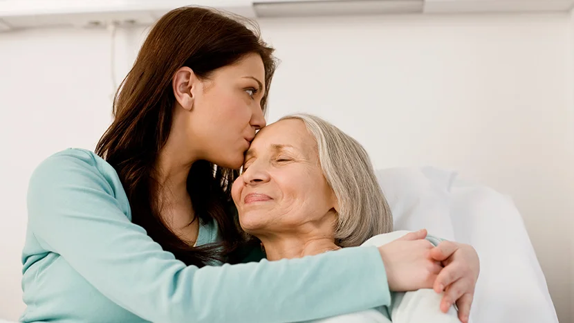 Μια γυναίκα φιλάει μια γυναίκα στο μάγουλο