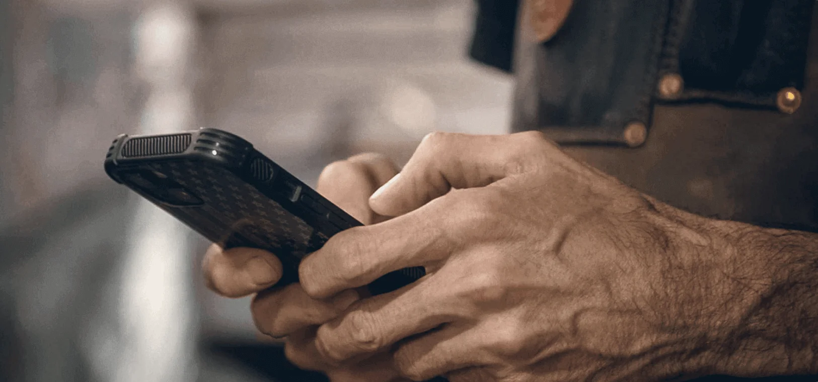 eine Person, die ein Mobiltelefon hält