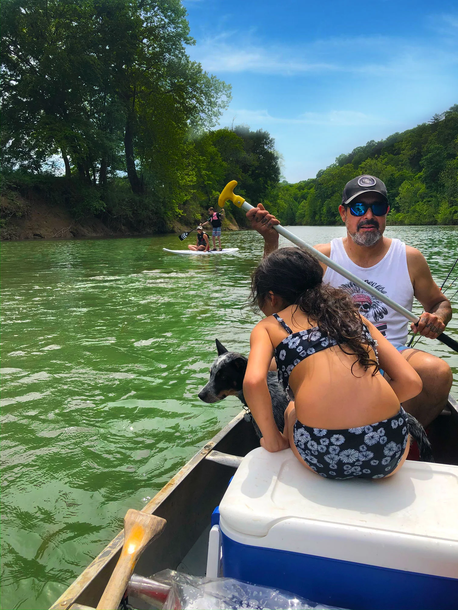 Muž a žena veslovajú na člne so psom